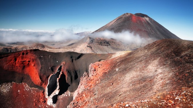 Eine verschneite Vulkanberglandschaft mit Dampfschwaden ist in der Umgebung von Christ's College zu sehen.