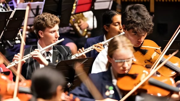 Eine Gruppe Musiker spielt verschiedene Instrumente auf der Bühne des Christ's College.