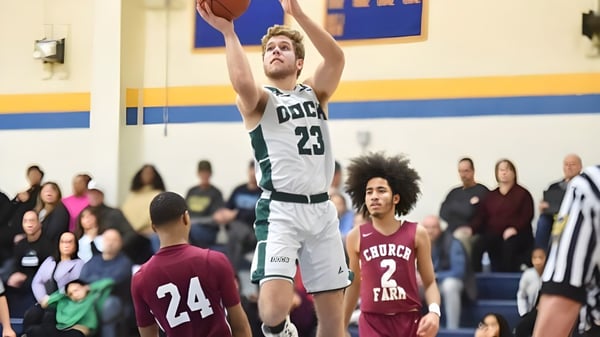Ein Basketballspieler der Church Farm School springt zum Korbwurf vor Zuschauern im Hintergrund.