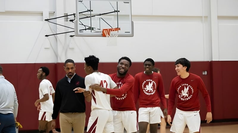 Eine Gruppe Schüler der Church Farm School steht auf dem Basketballplatz neben einem Korb.