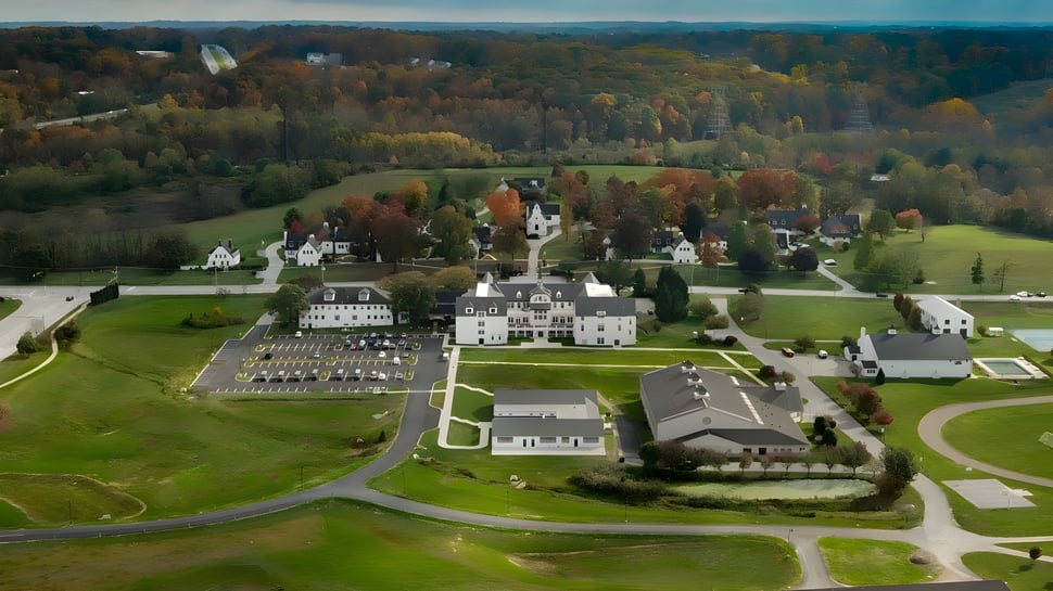 Die Church Farm School zeigt ihre weitläufigen Gebäude und gepflegten Anlagen in einer herbstlichen Landschaft.