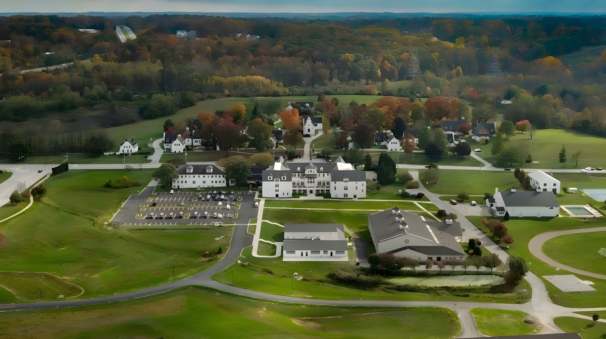 Die Church Farm School zeigt ihre weitläufigen Gebäude und gepflegten Anlagen in einer herbstlichen Landschaft.