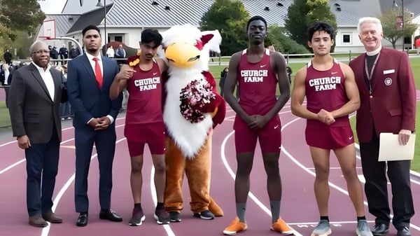 Schüler der Church Farm School stehen gemeinsam mit dem Maskottchen auf dem Sportplatz in einheitlichen Trikots.