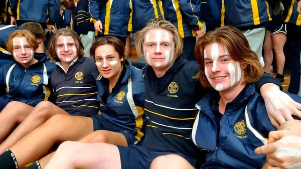 Eine Gruppe Schüler der Clare High School posiert in einheitlichen Uniformen bei einer Abschlussfeier.