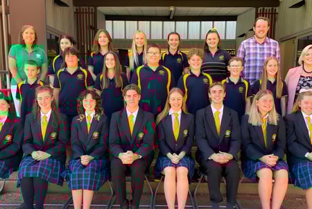 Eine Gruppe Schüler der Clare High School steht vor einem Schulgebäude zusammen.