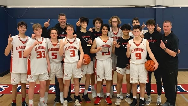 Schülerinnen und Schüler der Claremont Secondary School posieren gemeinsam in der Turnhalle als Basketballteam.