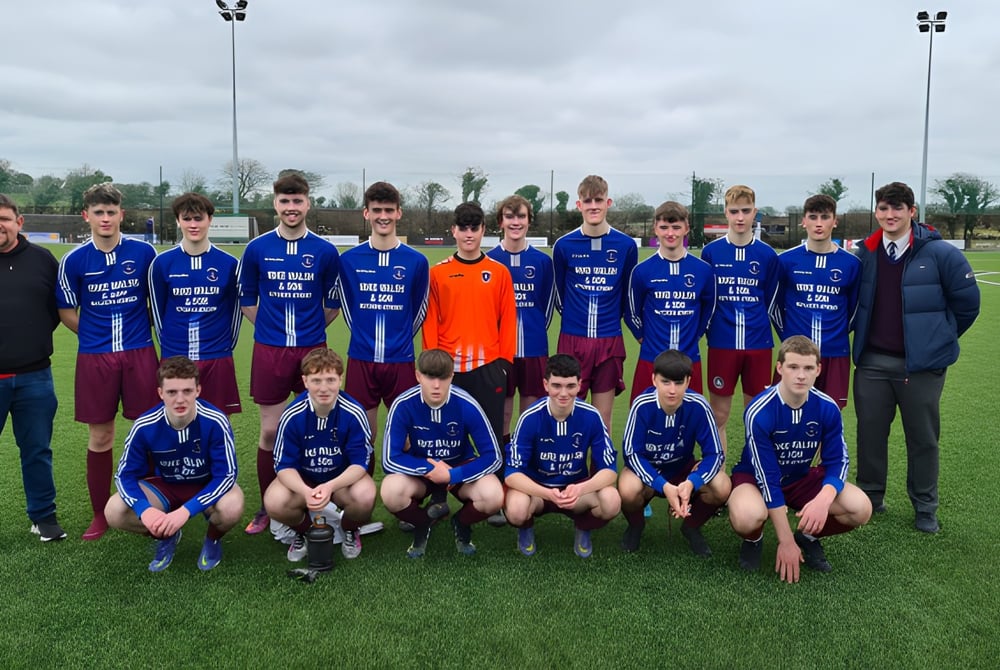 Eine Gruppe von Schülern des Clarin College posiert auf einem Rasenfeld vor bewölktem Himmel.