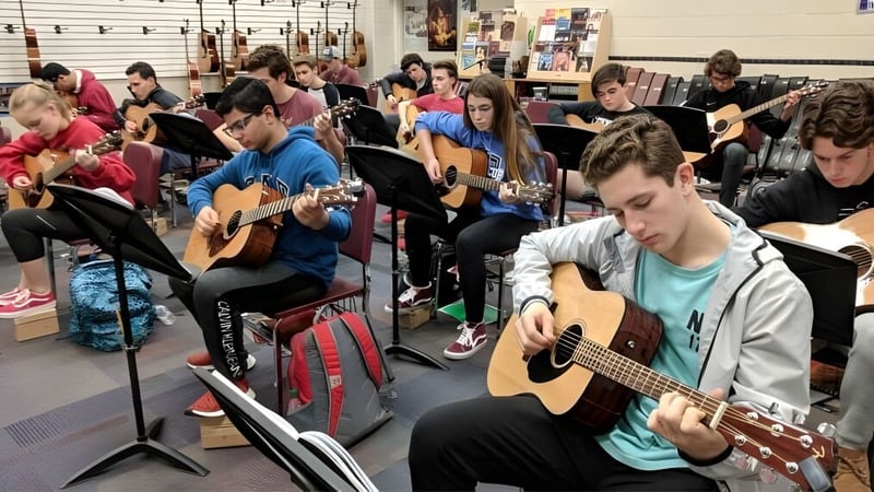 Eine Gruppe Schüler im Clark County School District spielt Gitarren und hört im Musikunterricht aufmerksam zu.