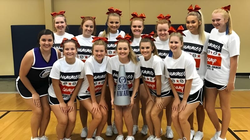 Eine Gruppe junger Cheerleaderinnen in einheitlichen Outfits posiert in der Sporthalle der Clarksville High School.