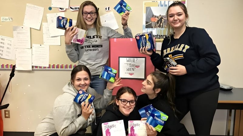 Eine Gruppe Schülerinnen zeigt verschiedene Schilder bei einer Aktivität in der Clayton Heights Secondary School.