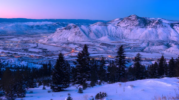 Eine verschneite Bergkette liegt im Hintergrund über der malerischen Stadt im Tal bei Clearwater Secondary School.