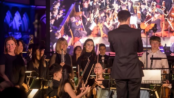 Das Orchester des Clifton College führt unter Leitung des Dirigenten ein Konzert auf der Bühne auf.