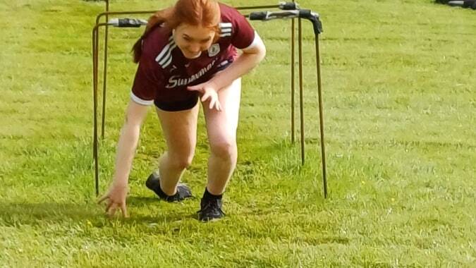 Eine Schülerin in Sportkleidung ist auf dem Sportplatz des Clonfert College in der Hocke zu sehen.