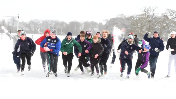 Schüler des Clongowes Wood College betreiben Langlauf auf einem verschneiten Waldweg.