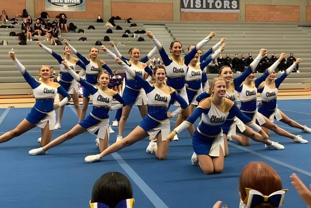 Eine Gruppe von Cheerleadern der Clovis High School führt eine synchronisierte Choreografie in der Turnhalle auf.