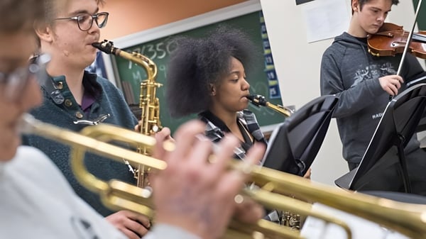 Schüler des Clovis Unified School District spielen im Musikunterricht verschiedene Instrumente wie Saxophon und Geige in einem Klassenraum.