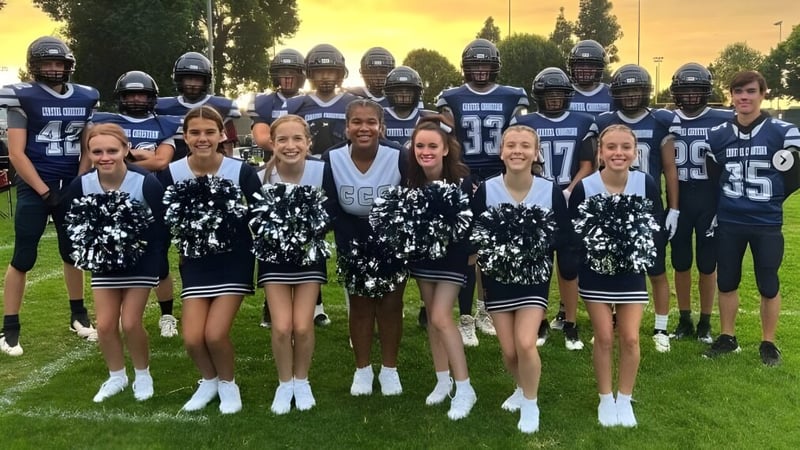 Schüler der Coastal Christian School posieren gemeinsam als Fußballspieler und Cheerleader auf einem Rasenfeld bei Sonnenuntergang.