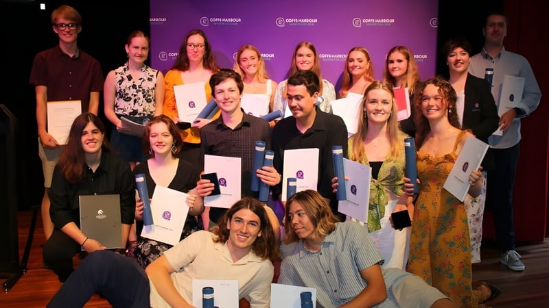 Eine Gruppe von Schülerinnen und Schülern des Coffs Harbour Senior College posiert gemeinsam vor einem lila Hintergrund mit Logo.