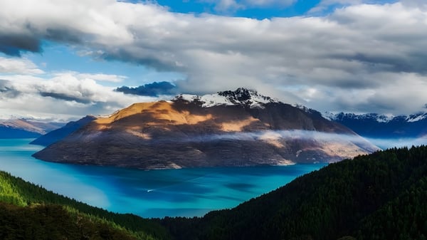 Ein Berg erhebt sich über einem türkisfarbenen See mit grünen Wäldern auf dem Gelände des Coffs Harbour Senior College.