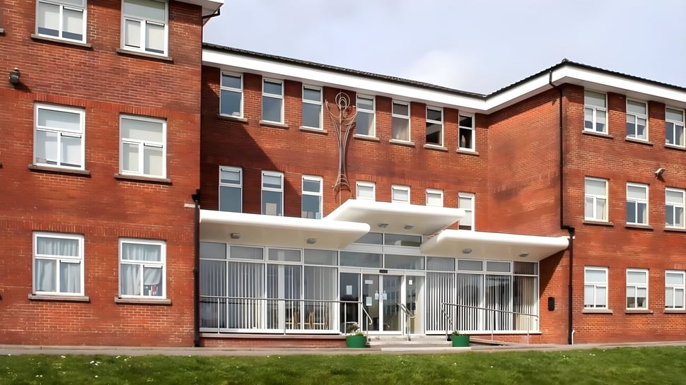 Das mehrstöckige Backsteingebäude mit verglastem Eingangsbereich auf dem Gelände der Colaiste Muire (Cobh).