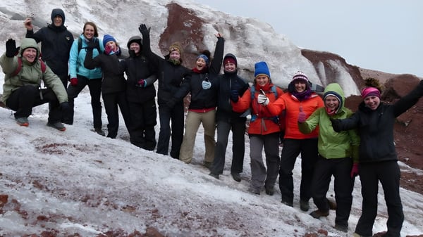 Schüler der Coláiste an Chreagáin stehen zusammen in winterlicher Berglandschaft mit Schnee bekleidet.