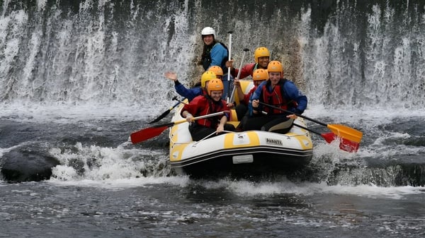 Schüler der Colaiste Chiarain Athlone fahren mit einem Schlauchboot an einem Wasserfall vorbei.