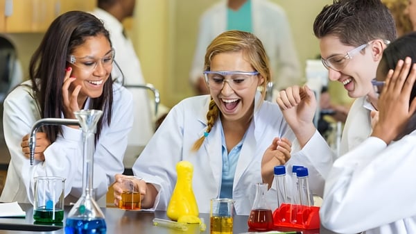 Schüler der Coláiste Éamann Rís diskutieren und experimentieren gemeinsam in einem Labor.