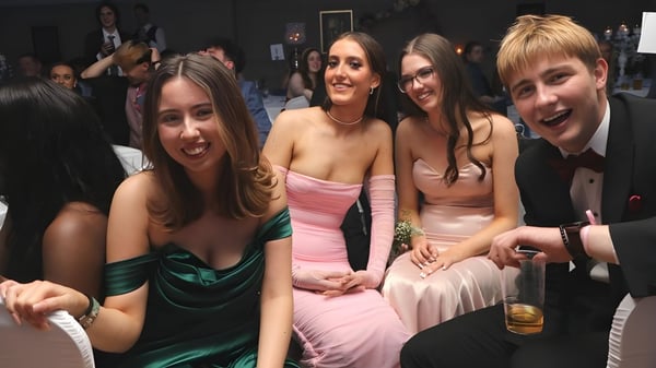 Eine Gruppe junger Frauen in formeller Kleidung bei einer Veranstaltung auf dem Campus der Coláiste Íosagáin.