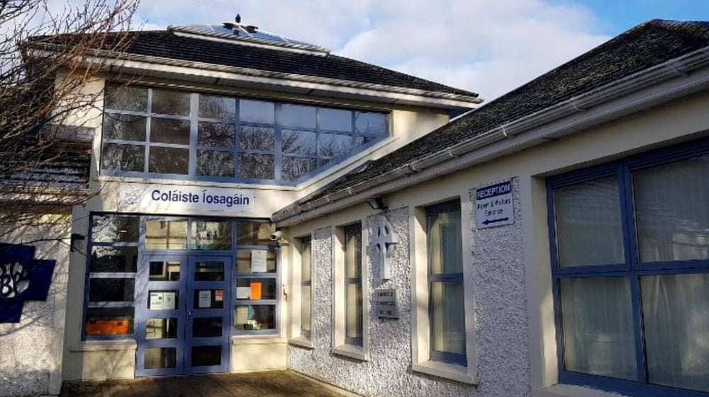 Ein kleiner Laden mit Glasfassade vor kahlen Bäumen auf dem Gelände der Coláiste Íosagáin.