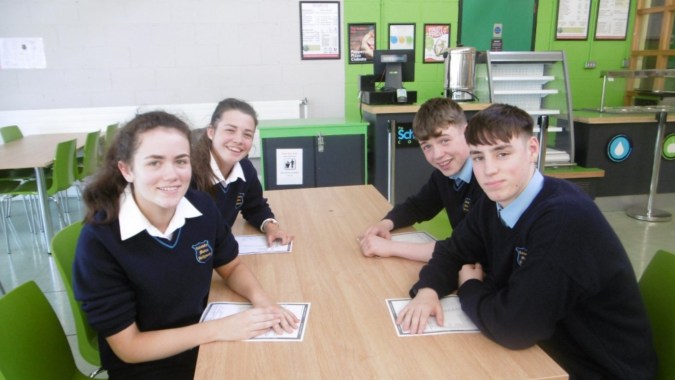 Eine Gruppe von vier Schülern sitzt an einem Tisch in einem Klassenzimmer der Coláiste Mhuire Ballymote.