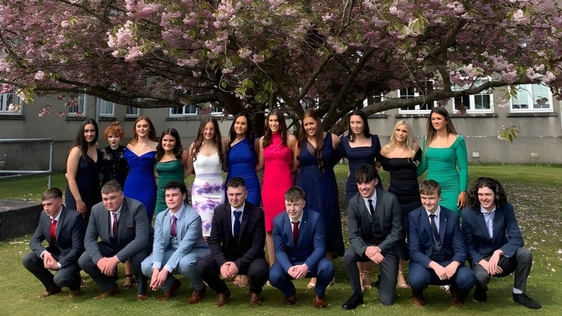 Eine Gruppe von Schülerinnen und Schülern der Colaiste Mhuire (Tourmakeady) steht vor einem blühenden Kirschbaum.