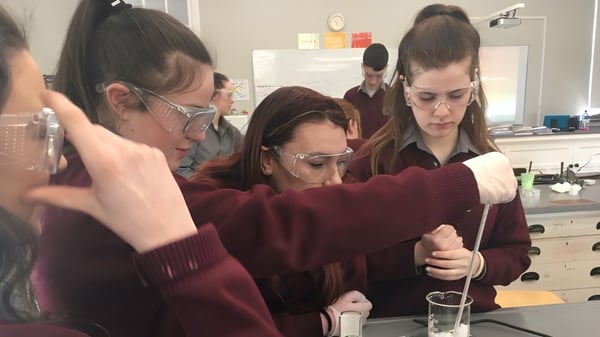 Schüler der Colaiste Mhuire (Tourmakeady) führen gemeinsam eine Laboraktivität an einem Tisch durch.