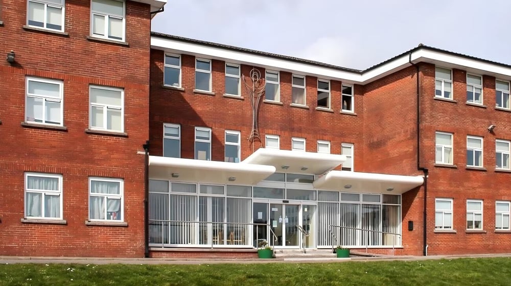 Das mehrstöckige Backsteingebäude mit großen Fenstern und verglaster Eingangshalle auf dem Gelände der Colaiste Muire (Cobh).