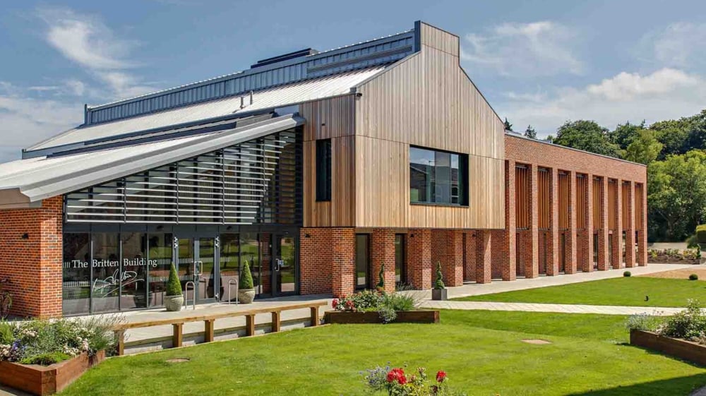 Das moderne mehrstöckige Gebäude von Coláiste Pobail Acla ist von gepflegtem Rasen und Bäumen umgeben.