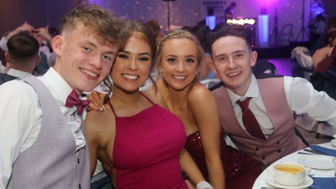 Eine Gruppe von vier jungen Menschen posiert bei einer Feier auf dem Campus der Coláiste Pobail Acla.