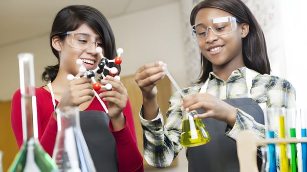 Zwei Schülerinnen und Schüler von Coláiste Pobail Acla unterhalten sich und untersuchen gemeinsam etwas im Labor.