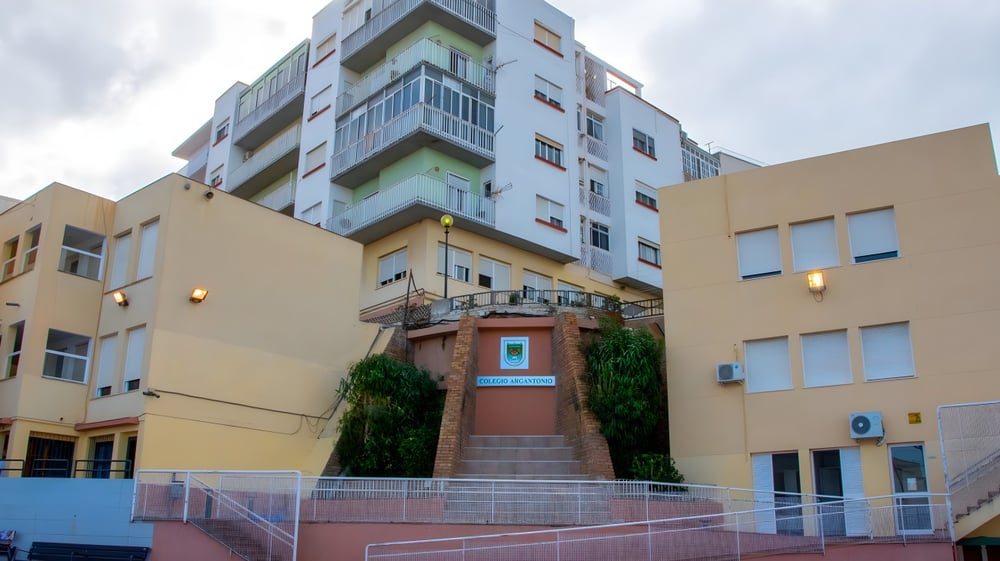 Das mehrstöckige Schulgebäude des Colegio Argantonio mit farbiger Außenfassade und Eingangsbereich mit Treppe.