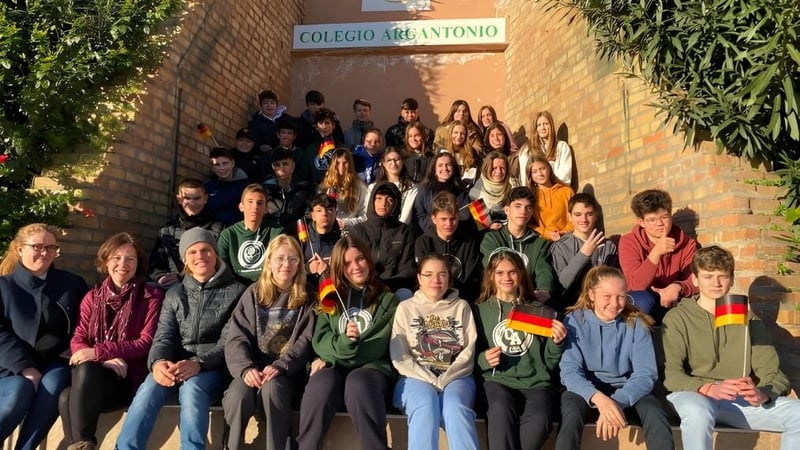 Eine Gruppe Schülerinnen und Schüler versammelt sich vor dem Schulgebäude des Colegio Argantonio.