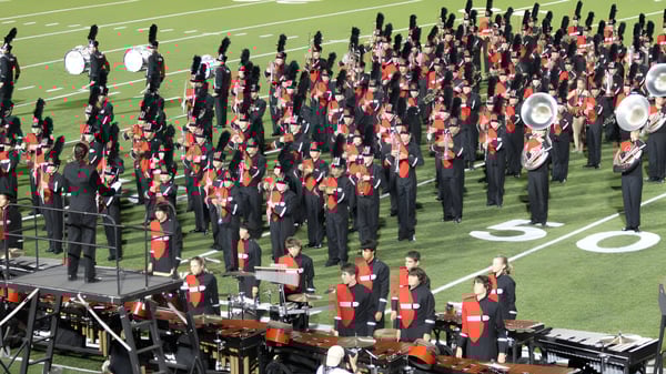 Die Marching Band von Collège Churchill High School spielt auf dem Footballfeld vor Zuschauern.