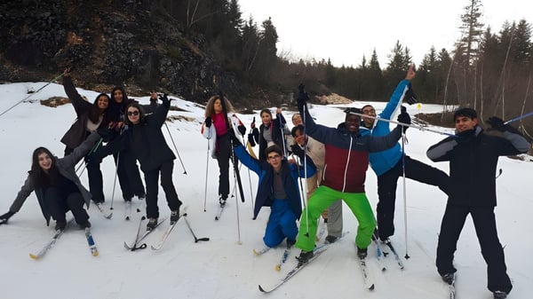 Schüler des Collège Episcopal Saint Étienne beim Skifahren auf einer verschneiten Waldstrecke.