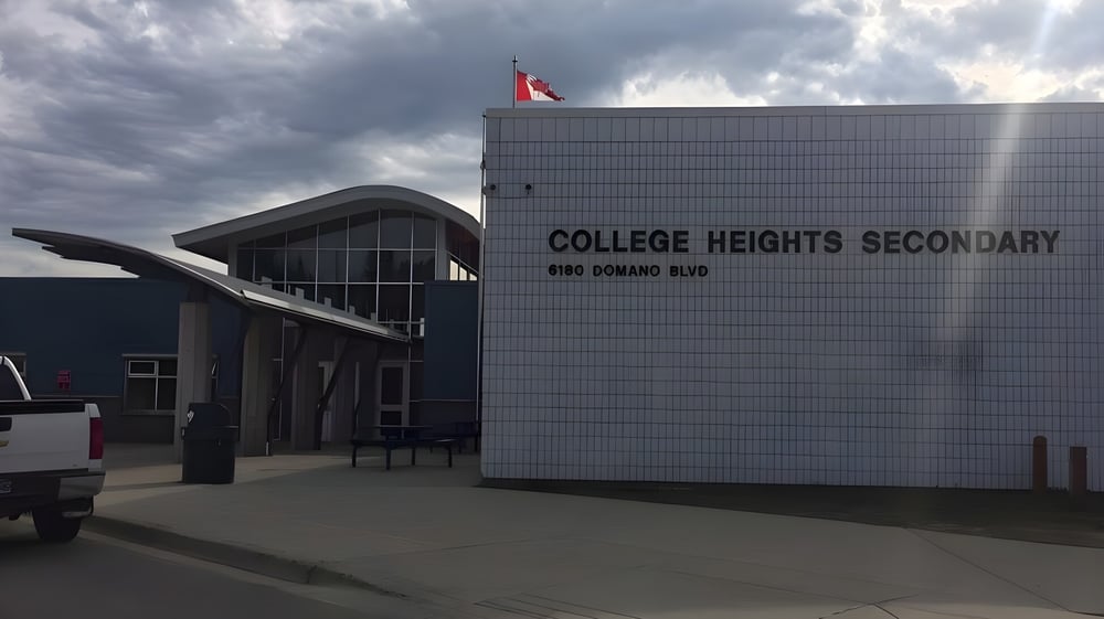 Das moderne Schulgebäude der College Heights Secondary School unter einem bewölkten Himmel.