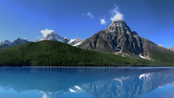 Das alpine Bergpanorama spiegelt sich im See vor dem Collège Notre-Dame.