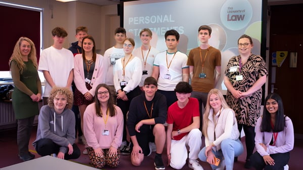 Eine Gruppe von Schülerinnen und Schülern des College of Richard Collyer posiert gemeinsam in einem Raum mit dem Schild 