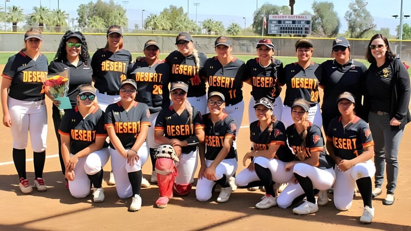 Eine Gruppe junger weiblicher Softball-Spielerinnen steht zusammen auf dem Sportplatz des College of the Desert.