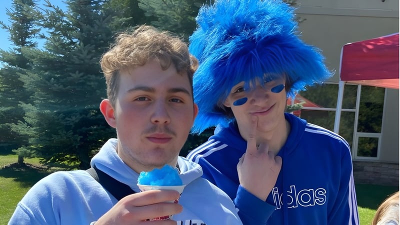 Zwei Schülerinnen des Collège Sacré-Coeur stehen draußen vor einem bewaldeten Hintergrund.