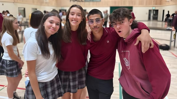 Eine Gruppe lächelnder Schüler steht gemeinsam im Flur des College Saint-Bernard.
