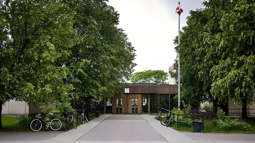Ein gepflasterter Weg mit Fahrrädern und Bäumen auf dem Campus der Colonel By Secondary School.