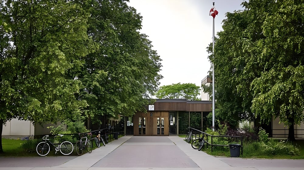 Ein gepflasterter Weg mit Fahrrädern und Bäumen auf dem Campus der Colonel By Secondary School.