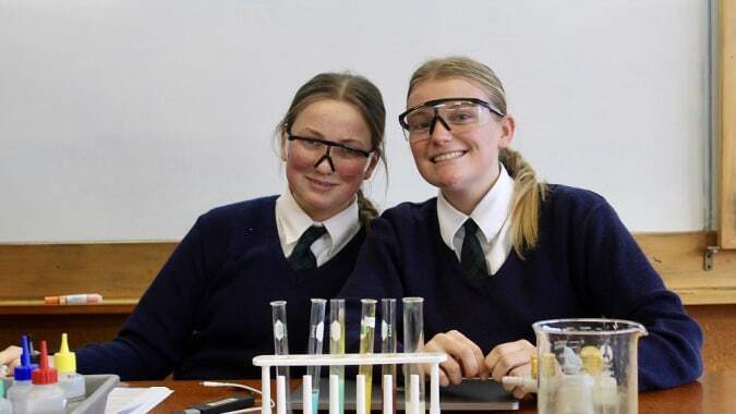 Zwei Schülerinnen des Columba College sitzen im Klassenzimmer an einem Tisch mit wissenschaftlichen Geräten.
