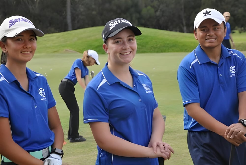 Drei Schüler in blauen Uniformen stehen auf dem Golfplatz des Como Secondary College vor Bäumen.